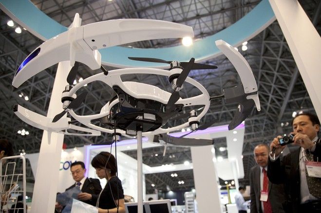 Visitors take photos of a drone on display at the International Drone Expo 2015 ...