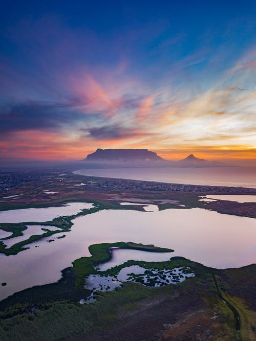 Amazing sunset over mountainous landscape with lakes and coastline · Free Stock Photo